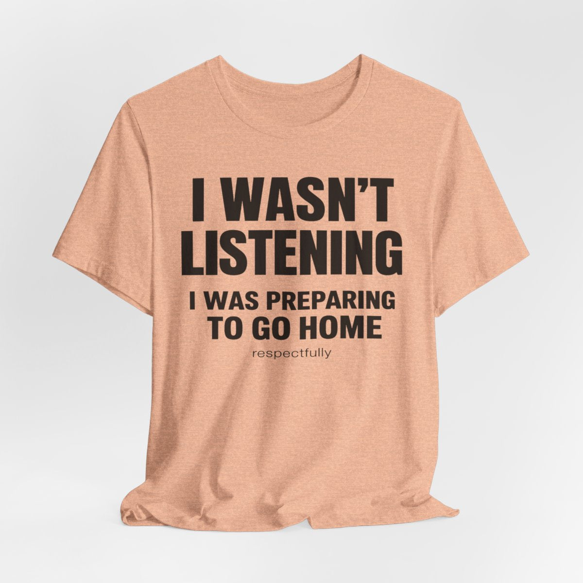 I Wasn't Listening, I Was Preparing to Go Home Funny T-Shirt — Heather Peach flat lay